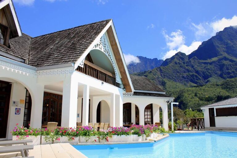 Alt: Luxus-Ferienhaus in Afrika mit Pool und malerischen Bergen im Hintergrund.