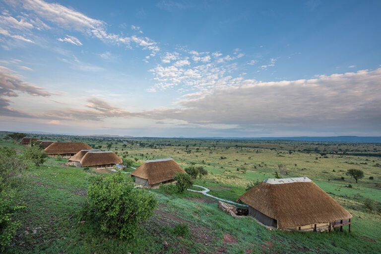 Hütten im afrikanischen Buschlandschaft, Sonnenuntergang, Wildtiere, Ostafrika.