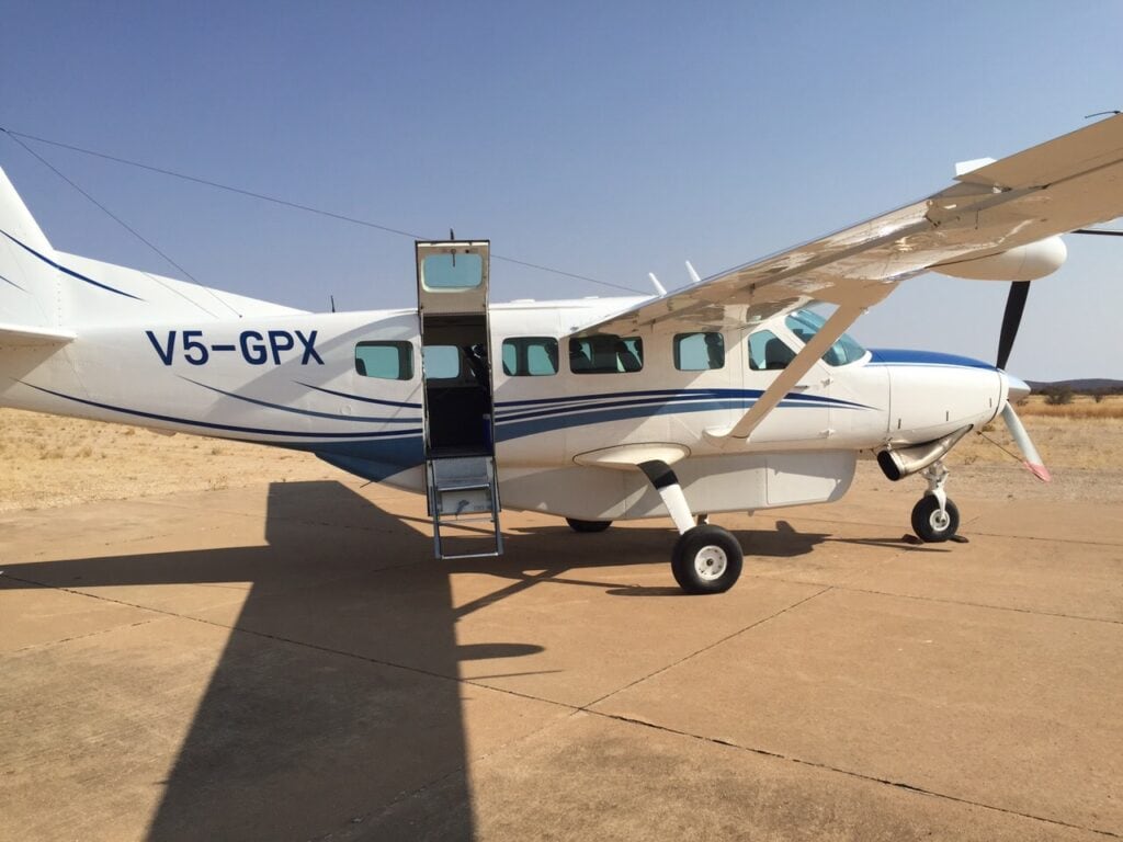 Moderne Cessna Maschine in afrikanischer Wüstenlandschaft.