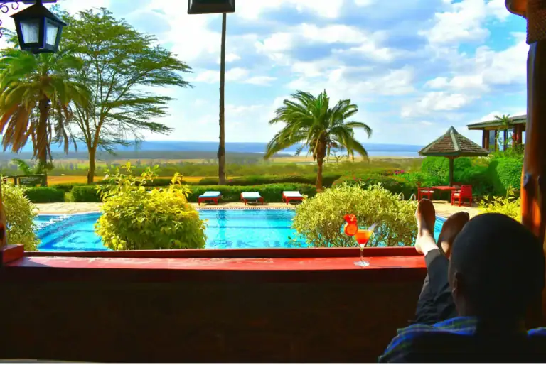 Entspannende Urlaubsatmosphäre mit Blick auf den afrikanischen Horizon, Palmengarten und Pool, ideales Reiseziel für Afrika Reiseerlebnisse.