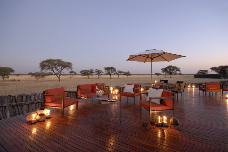 Luxuriöse Safari Lodge im afrikanischen Busch bei Sonnenuntergang, ideal für Safari und Naturerkundungen.