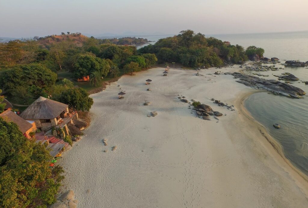 Traumhafter afrikanischer Strand mit Pakments, Sunloungers und Palmen, perfekt für einen erholsamen Urlaub.