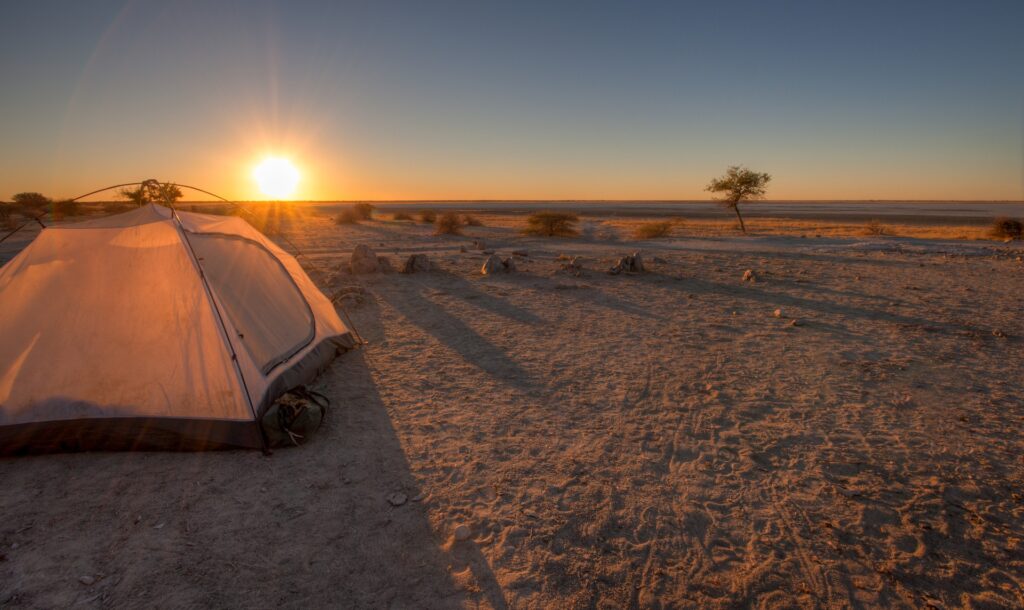 Geführtes Zeltcamp in der afrikanischen Wüste bei Sonnenuntergang, Safari in Namibia, Sahara.