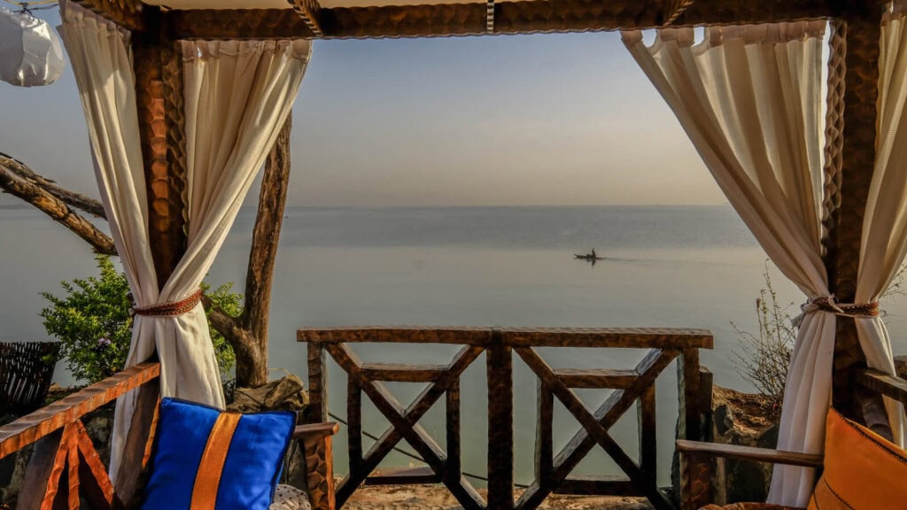 Entspannende afrikanische Strandhütte mit Blick auf das Meer bei Sonnenuntergang.