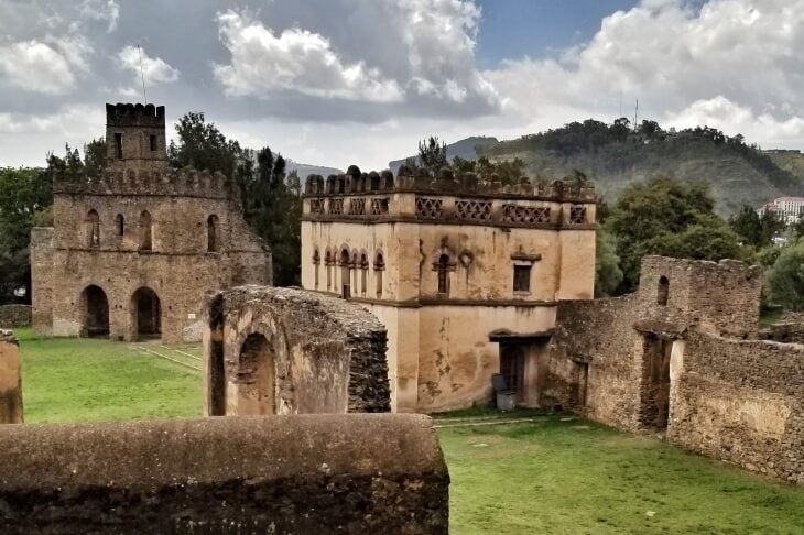 Burgruine in Afrika, historische Festung mit Mauern und Türmen, umgeben von grüner Landschaft.