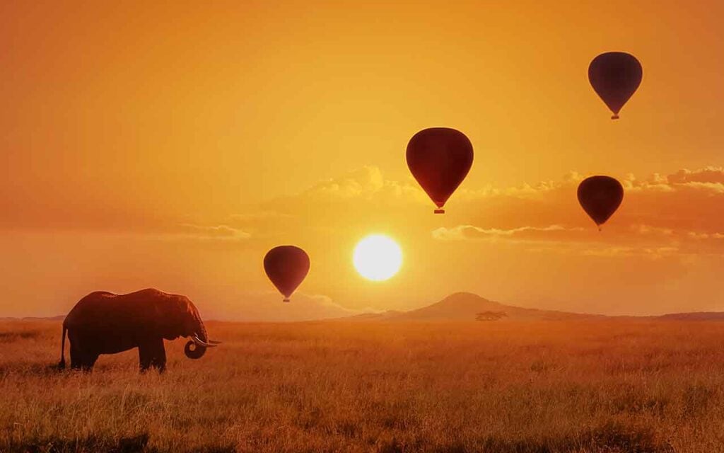 Alt: Heißluftballons über der afrikanischen Savanne bei Sonnenaufgang.