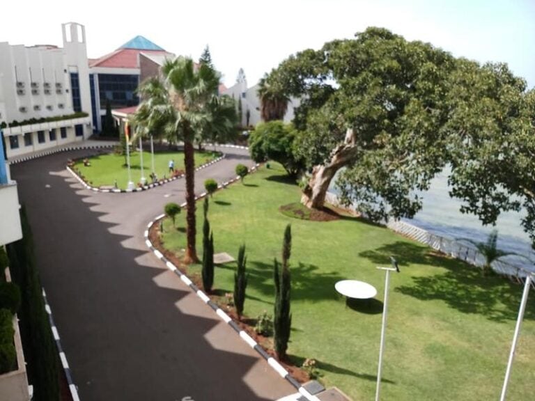 Schöne afrikanische Hotelanlage mit Blick aufs Wasser, Palmen, gepflegtem Garten in Afrika.