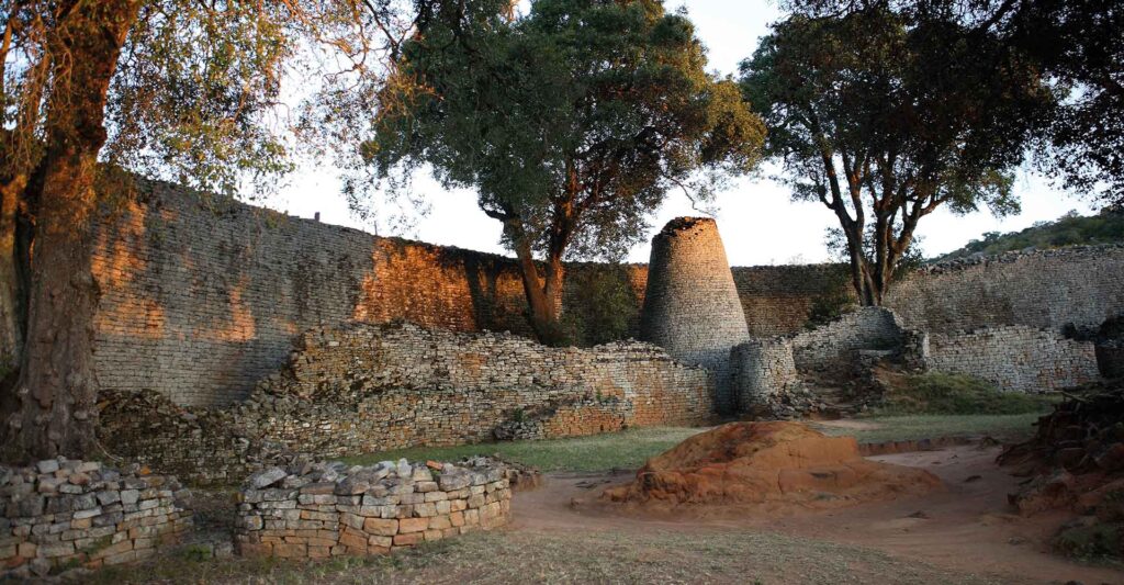 Alte Sandsteinmauer und Baum im südafrikanischen Busch, historische Afrikareise.