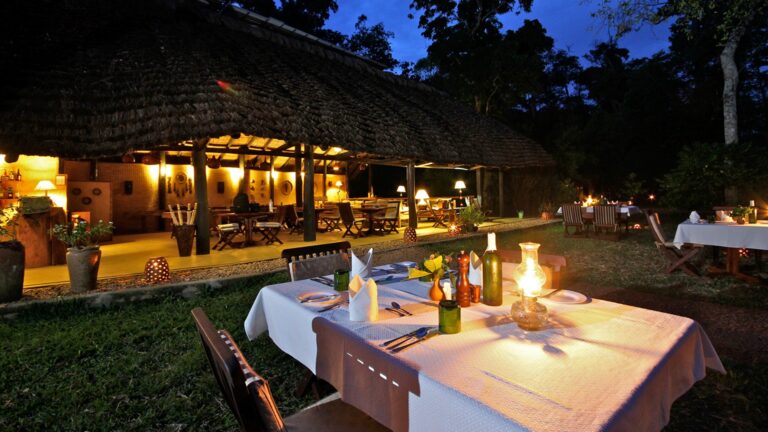 Teller und Kerzenlicht bei Dinner im afrikanischen Safari-Restaurant in der Natur.