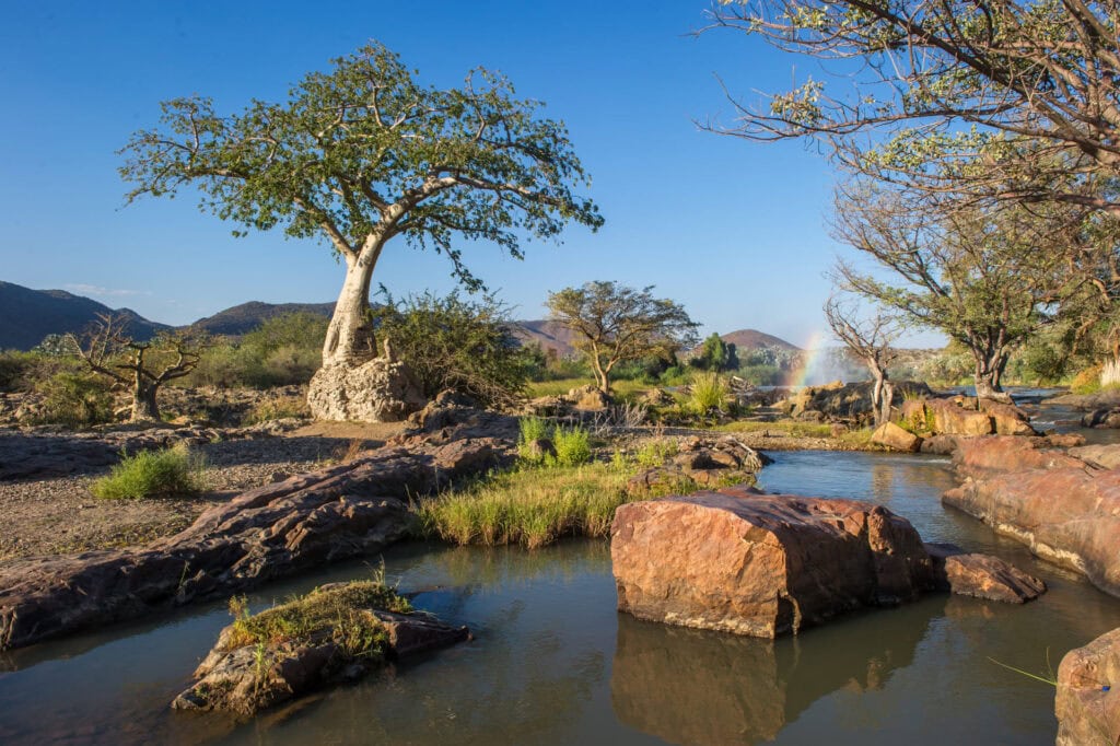 Alter Text: Landschaft in Namibia mit Baobab-Bäumen, Fluss, Wasserfall & Savannen, Afrikas Natur.