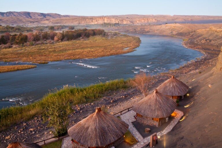 Hohe Auflösung, afrikanische Natur, Safari, Flusslandschaft, Sambesi, Bäume, Hütten, Sonnenuntergang, Wilde Tierwelt, Tourismus.