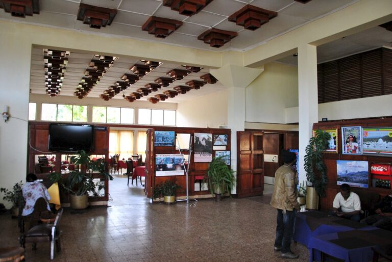 Innenansicht eines afrikanischen Reisebüros mit Informationsmaterial und Sitzgelegenheiten.