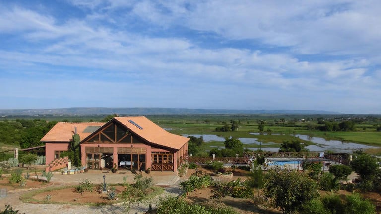 Häuser in der afrikanischen Natur mit Blick auf Flüsse, ideal für Safari Reisen in Afrika.