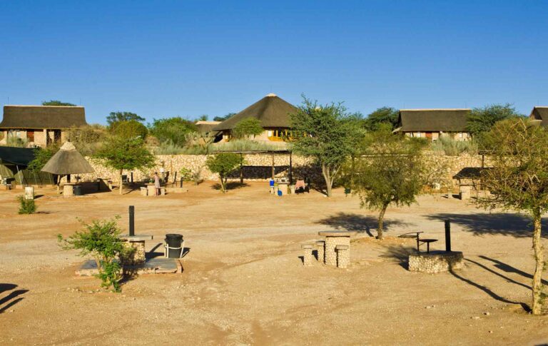 Chalets und Unterkünfte im afrikanischen Stil, Sonnenuntergang, Wildtiere, Safari-Abenteuer, Tempelarchitektur.