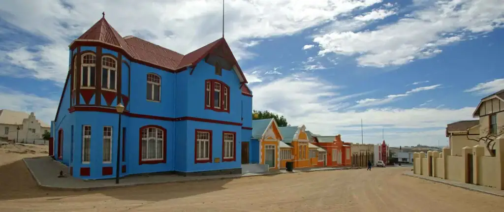 Buntes afrikanisches Haus in Namibia mit traditioneller Architektur und Sonnenschein.