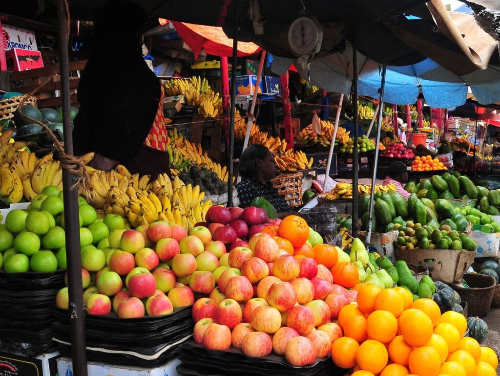 Bunte afrikanische Früchte, Melonen, Bananen, Äpfel und Orangen auf einem Markt in Afrika.