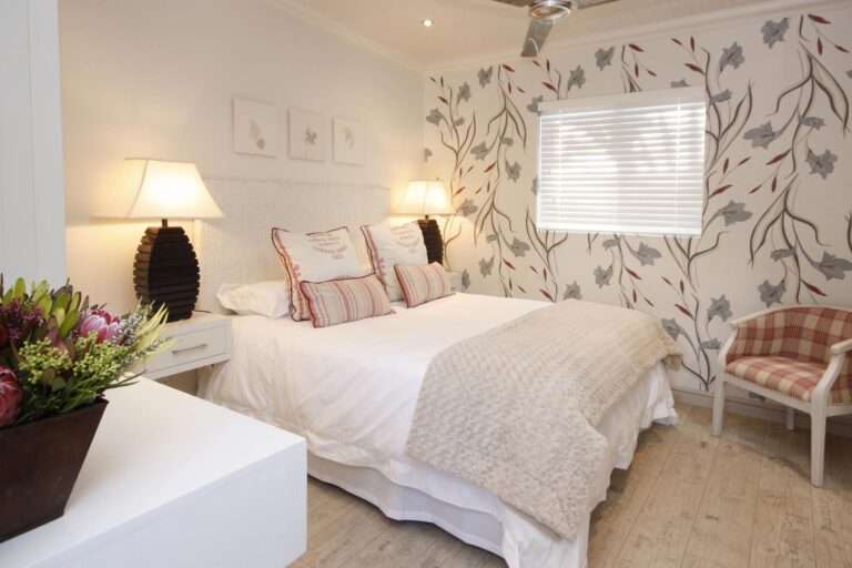 Schlafzimmer mit Blumenmuster Wanddeko, bequemer Bett, afrikanischer Atmosphäre, Hotel in Afrika, Urlaubswohnung.