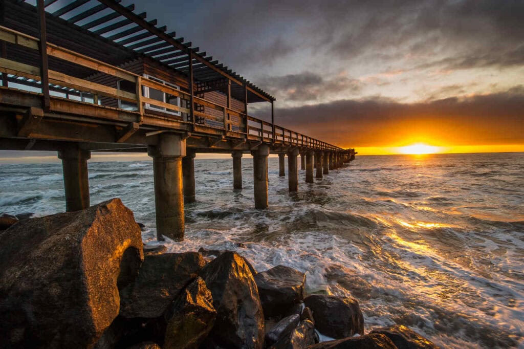 Alt: Malerischer Sonnenuntergang über dem Atlantik mit Strandpromenade in Afrika.