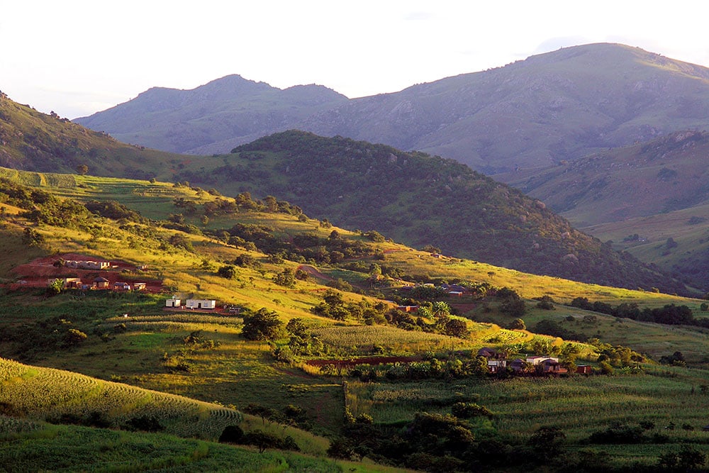 Berglandschaft in Afrika mit grünen Hügeln und Dörfern, ideal für Afrika-Reisen.