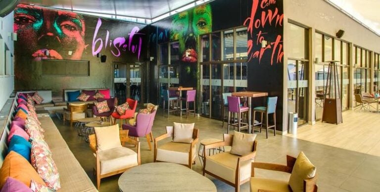 Gemütliche Sitzecke im afrikanischen Retreat mit bunten Kissen und moderner Dekoration.