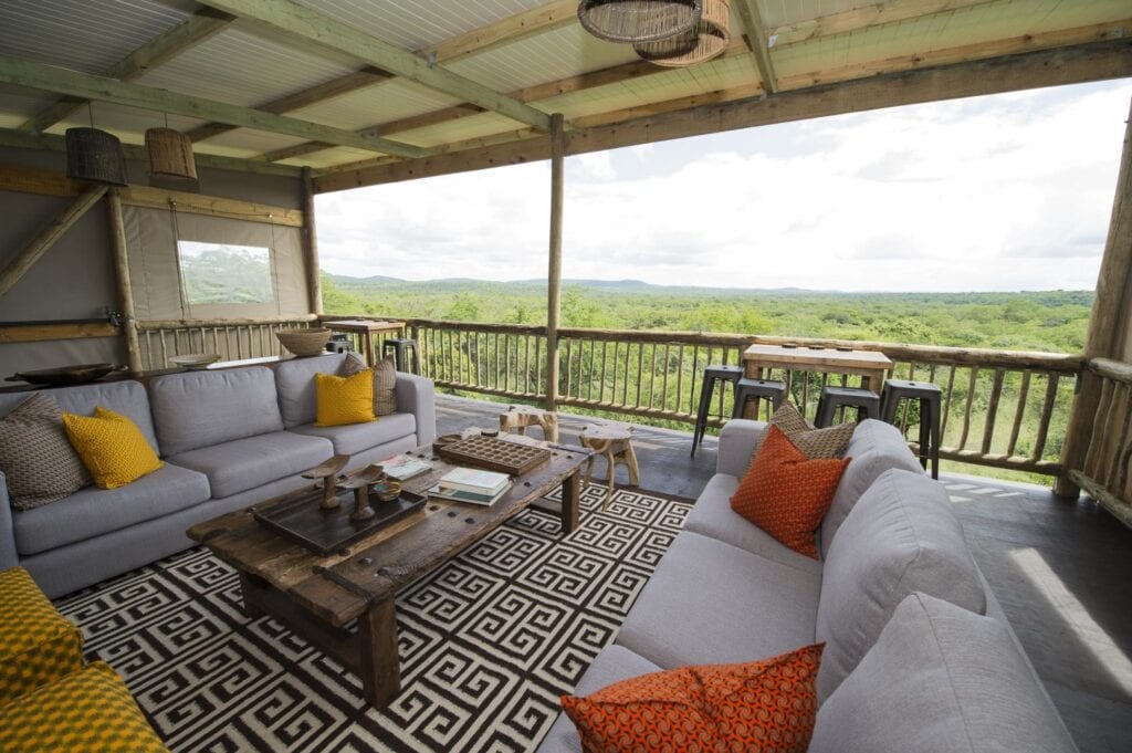 Gemütliche Safari-Lodge Terrasse mit Blick auf die afrikanische Savanne, komfortable Sitzgelegenheit.
