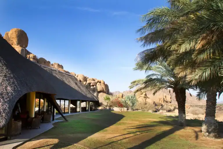 Luxus Safari Lodge in Afrika mit Palmen und Wüstenblick.
