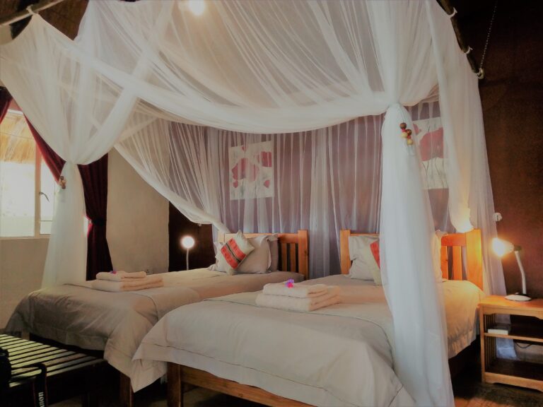 Hell erleuchtetes afrikanisches Safari-Zimmer mit Himmelbett, Moskitonetz und stilvoller Dekoration.