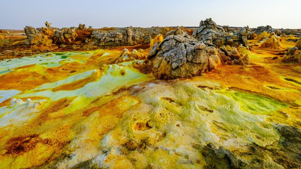 Farbenfrohe Gesteinslandschaft mit schillernden Thermalquellen in Afrika, einzigartiges Naturerlebnis.
