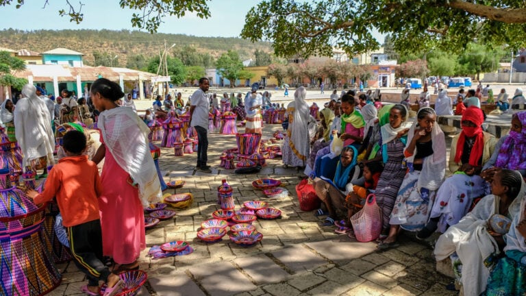 Menschen beim Handwerk auf einem afrikanischen Markt, lebendige Farben, authentische Kultur in Afrika.