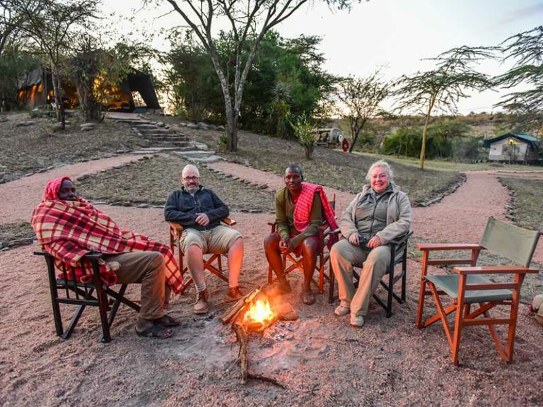 Alteingesessene Safari-Gäste am Lagerfeuer in Afrika.