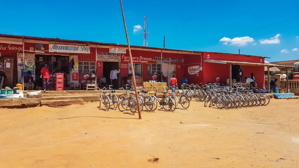 Straßenmarkt in Afrika mit Fahrrädern, sonniger Tag, lebendige Atmosphäre, authentische afrikanische Reiseerfahrung.