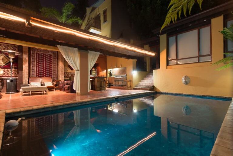 Erholsamer Swimmingpool im luxuriösen afrikanischen Hotel mit marokkanischer Atmosphäre bei Nacht.