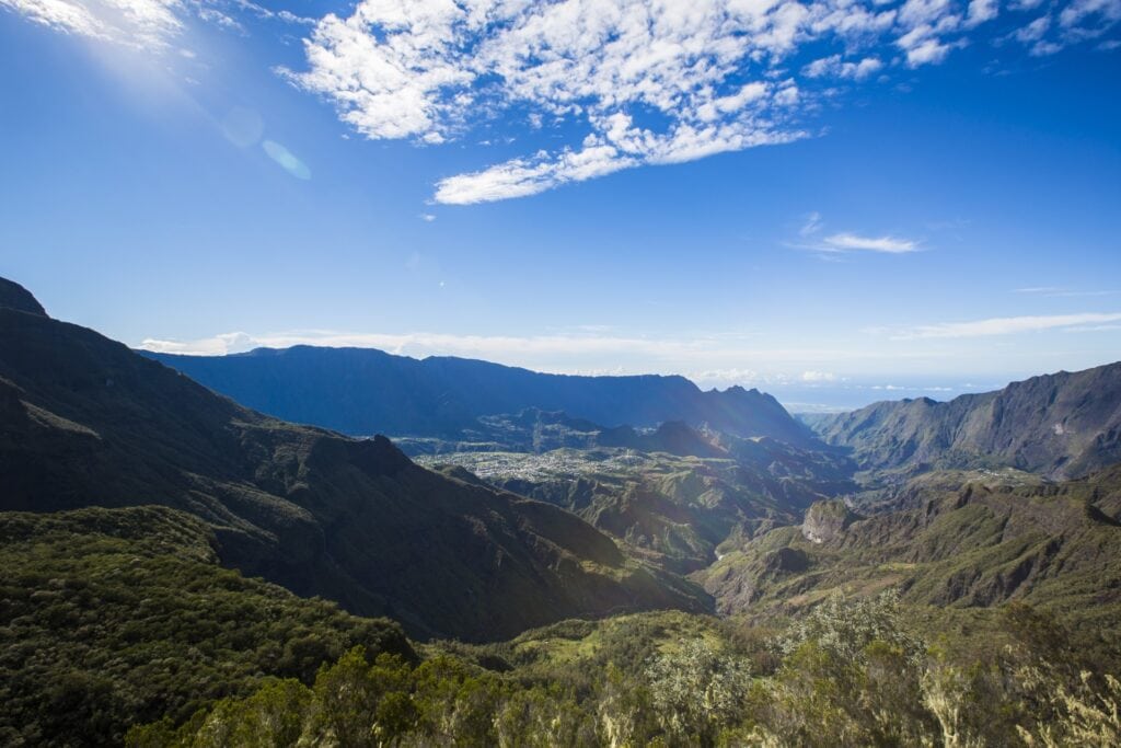 Berglandschaft in Afrika mit bewaldeten Hügeln und blauem Himmel.