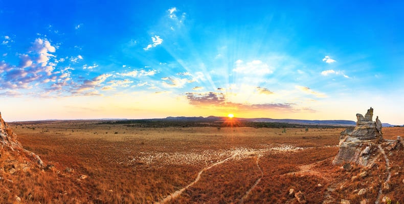 Alt: Atemberaublicher Sonnenuntergang in der afrikanischen Savanne mit weiten Ebenen.