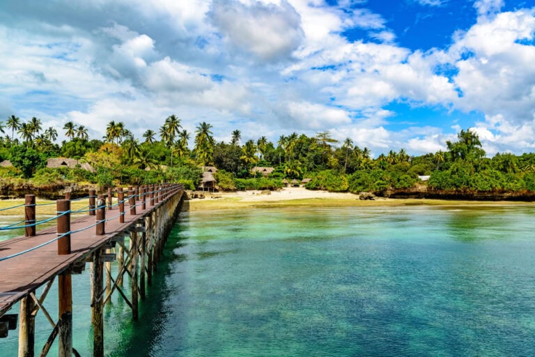 Strand mit Holzsteg, Palmen und blauer Himmel für Afrika-Reisen, Traumurlaub, Safari.
