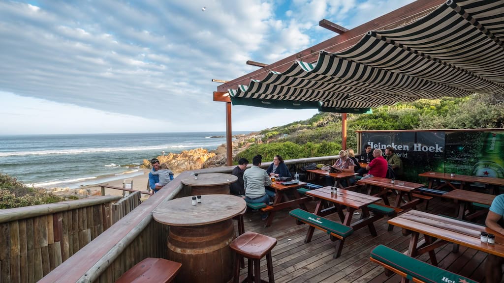 Bilder von einer Strandbar in Afrika mit Meerblick, Holzdecks und entspannten Gästen.