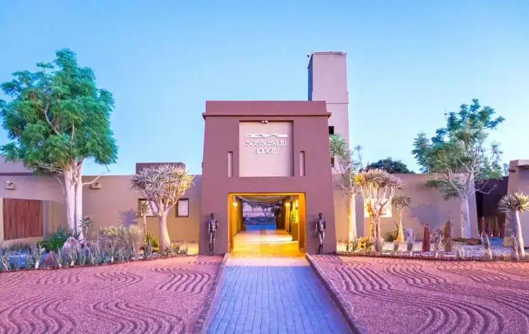 Alt-Text: Luxuriöse Lodge im afrikanischen Wüstenparadies mit Sonnenuntergang in der Wüste.