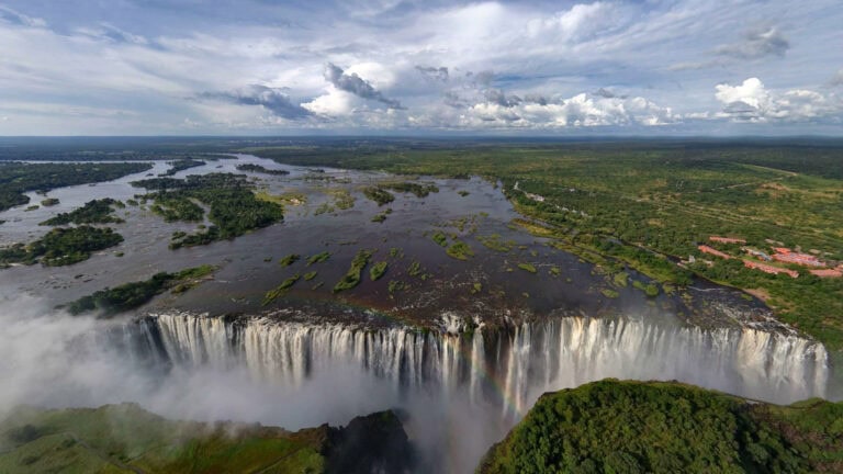 Atemberaubender Blick auf den Victoriafall in Afrika, umgeben von üppigem Regenwald und Wasserfällen.