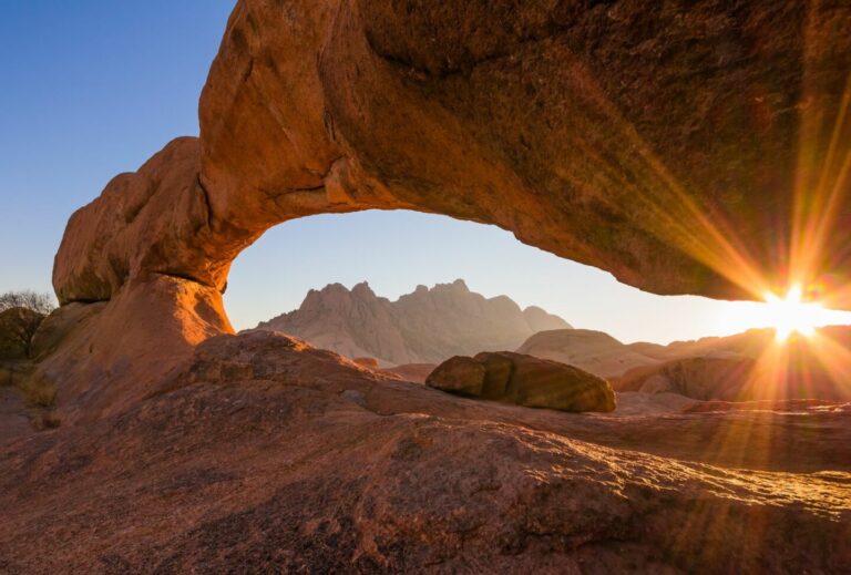 Ausblick auf die Namib-Wüste mit Felsformationen bei Sonnenuntergang.