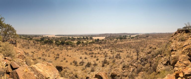 Weite afrikanische Steppe mit Felsen und Dünen, ideal für Safari- und Naturerkundungen.