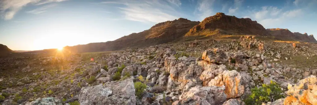 ALt: Sonnenuntergang über Felsen im afrikanischen Gebirge, warmes Licht, Afrika Reisen.