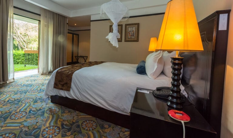 Gemütliches Schlafzimmer mit Blick auf Garten in Afrika.