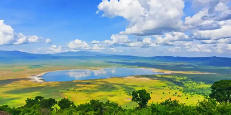 Schöner Blick auf einen malerischen, ruhigen See inmitten africaner Steppe, umgeben von grüner Natur.