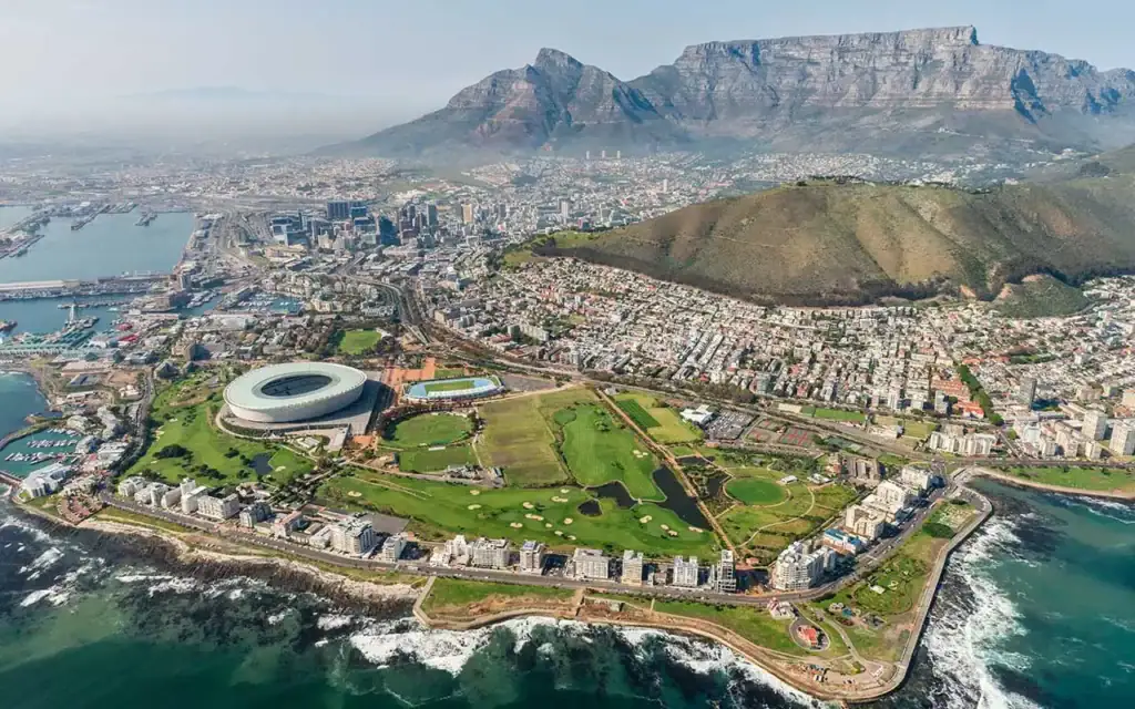 Breite Luftaufnahme von Kapstadt mit Tafelberg im Hintergrund und Blick auf Stadtküste.