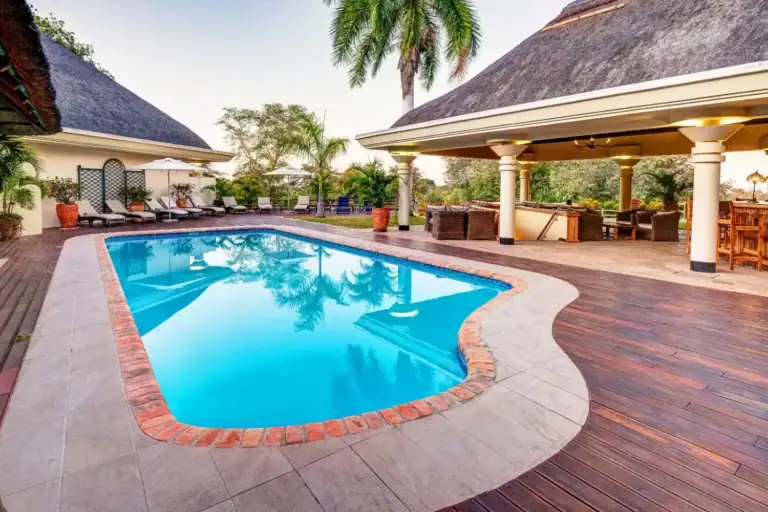 Heller Außenpool mit Palmen und entspanntem Lounge-Bereich in Afrika.
