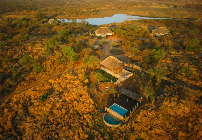 Häuser im Busch bei Sonnenuntergang in Afrika, luxuriöse Safari Lodges, Tierwelt, Abenteuerreisen.