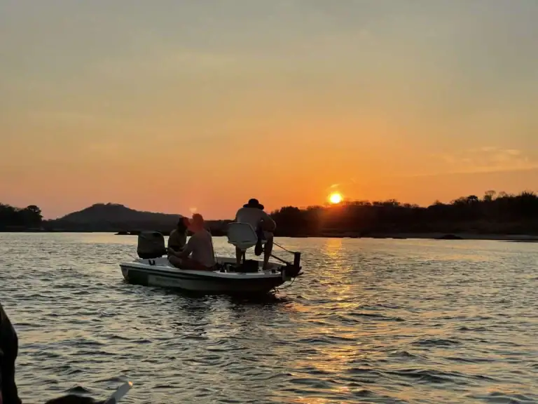 Boot mit Touristen bei Sonnenuntergang in Afrika.