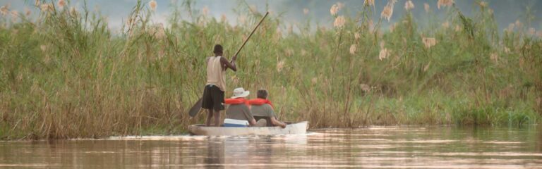 Alt: Ein Boot auf einem Fluss in der Serengeti, umgeben von Grasland und Natur, afrikanische Tierwelt erleben.