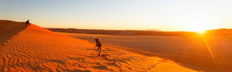 Menschen in der Sahara bei Sonnenuntergang, Abenteuer in Afrika, Wüstentour, Erlebnis in der Natur.