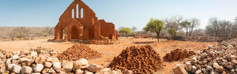 Alte, verfallene Ruinen in Afrika, mit antikem Charme, umgeben von Staub und Natur.